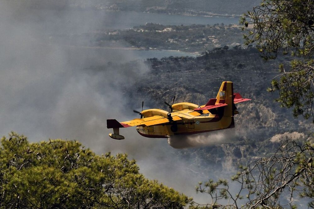 Wildfires lead to evacuations in Greece  / VASILIS PSOMAS