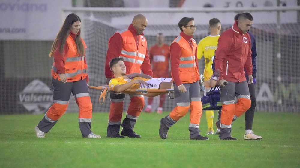 Javi Fontán en el momento de abandonar el terreno de juego en camilla.