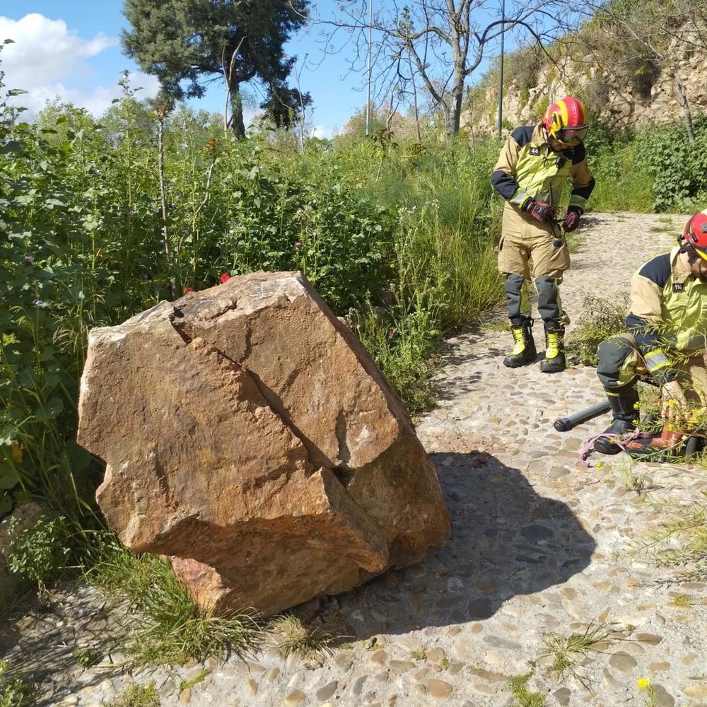 Los bomberos ‘vuelan’ una roca caída bajo el puente de La Cava