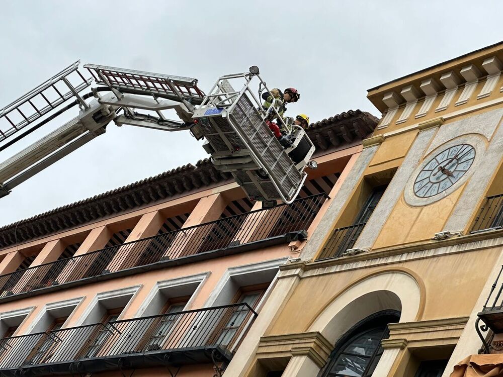 Bomberos subidos en la grúa para realizar labores de saneamiento.