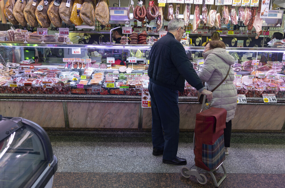 Una pareja compra en una charcutería en un mercado